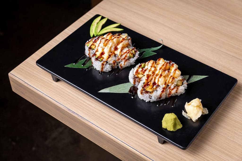 Baked Scallop Roll. California roll base topped with scallop, baked with house sauce, and drizzled with eel sauce.