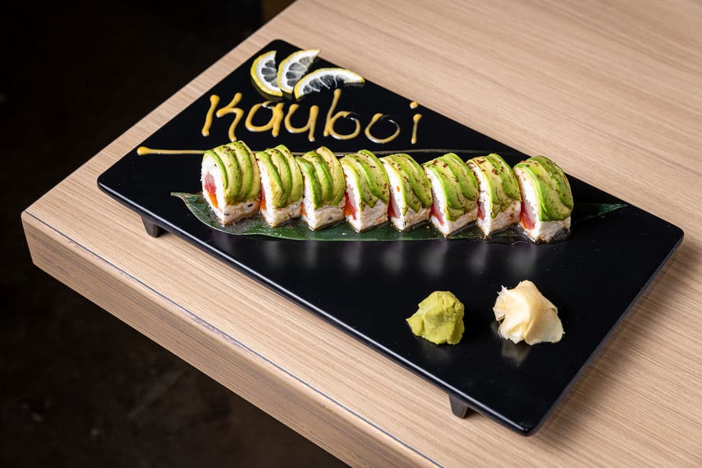 Kauboi Roll. Crabmeat, tuna, salmon, yellowtail inside. Topped with avocado and soy mustard sauce on the side.