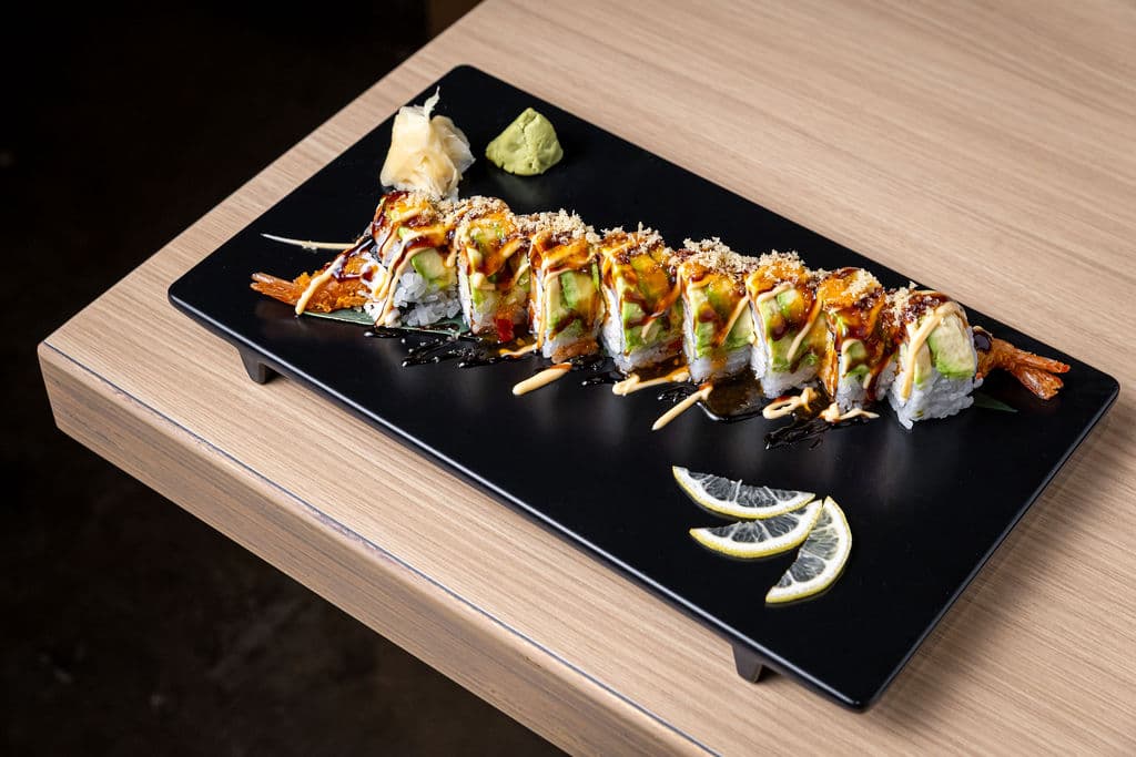 Mamacita Roll. Shrimp tempura, crabmeat, avocado inside. Topped with spicy tuna & avocado. Finished with eel sauce, spicy mayo, and sweet chili sauce.