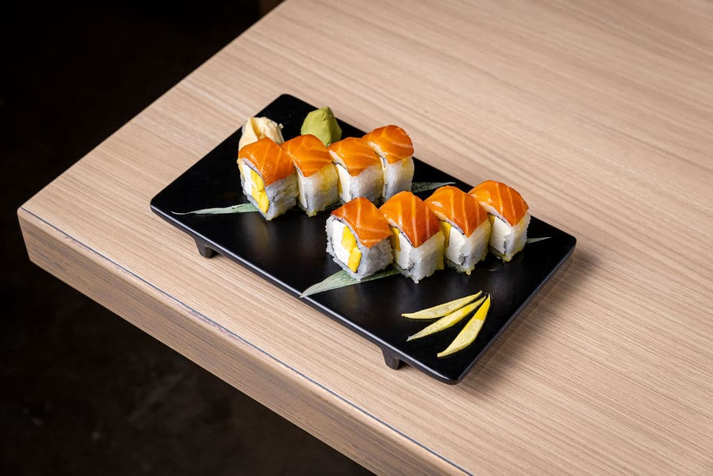 Salmon Delight Roll. Cream cheese and mango inside. Topped with salmon and mango sauce.